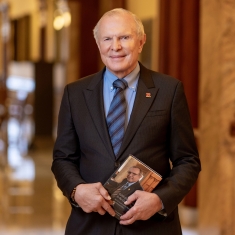 Senator Raymond Lesniak holding memoir in New Jersey statehouse. Photo by John O’Boyle.